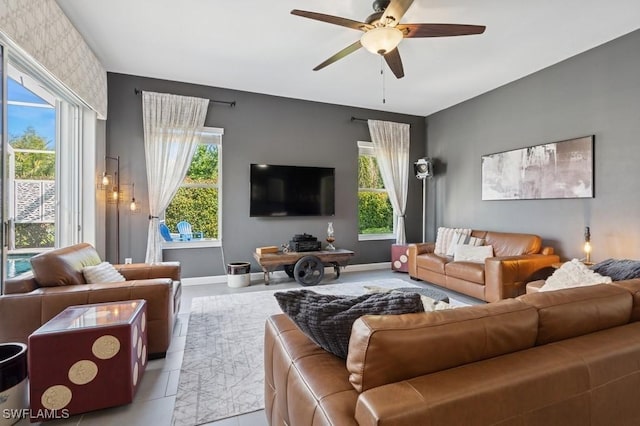 tiled living room featuring baseboards and a ceiling fan