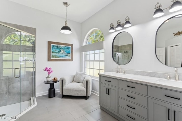 bathroom featuring a sink, baseboards, double vanity, and a shower stall