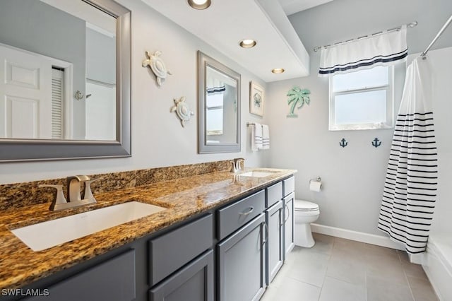 bathroom featuring tile patterned flooring, double vanity, toilet, and a sink