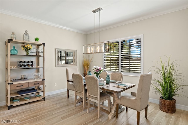 dining area featuring an inviting chandelier, crown molding, baseboards, and wood finish floors