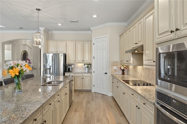 kitchen with a sink, stainless steel appliances, and cream cabinets