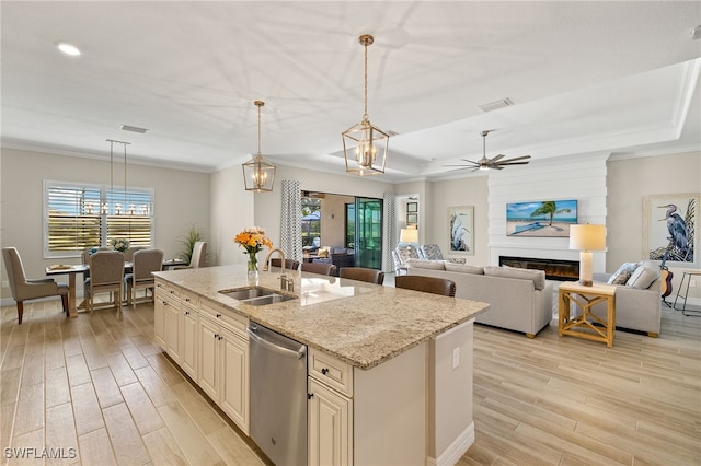 kitchen featuring visible vents, light wood finished floors, a sink, cream cabinetry, and dishwasher