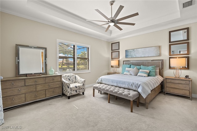 bedroom featuring a tray ceiling, crown molding, visible vents, and light carpet