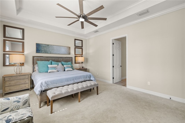 carpeted bedroom with a tray ceiling, baseboards, visible vents, and crown molding