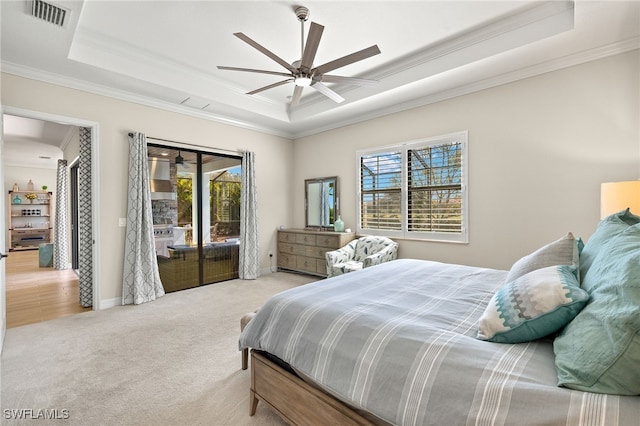 bedroom featuring a tray ceiling, visible vents, ornamental molding, and carpet flooring