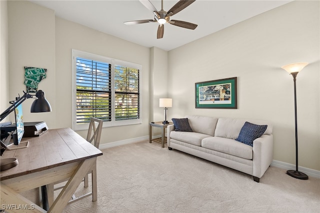 office space with light colored carpet, baseboards, and a ceiling fan