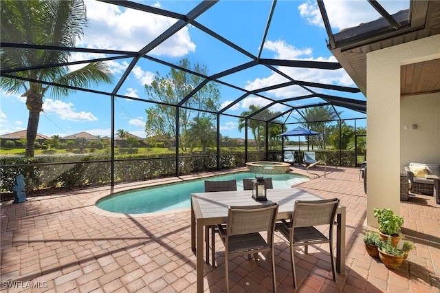 view of swimming pool featuring glass enclosure, a patio, and a pool with connected hot tub