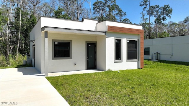 view of front of house with a front yard and stucco siding