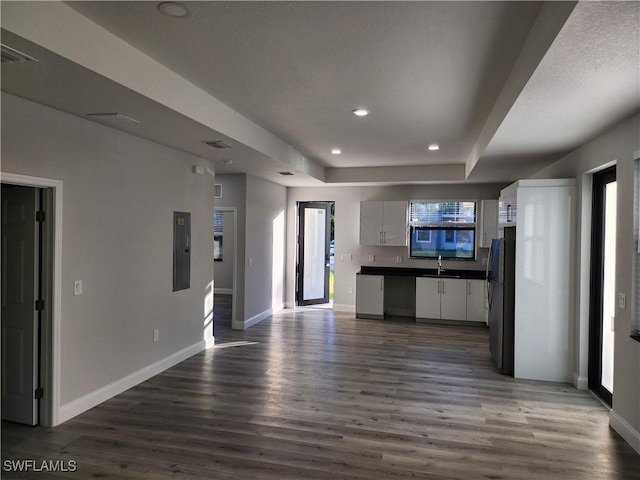 kitchen featuring wood finished floors, baseboards, recessed lighting, freestanding refrigerator, and dark countertops