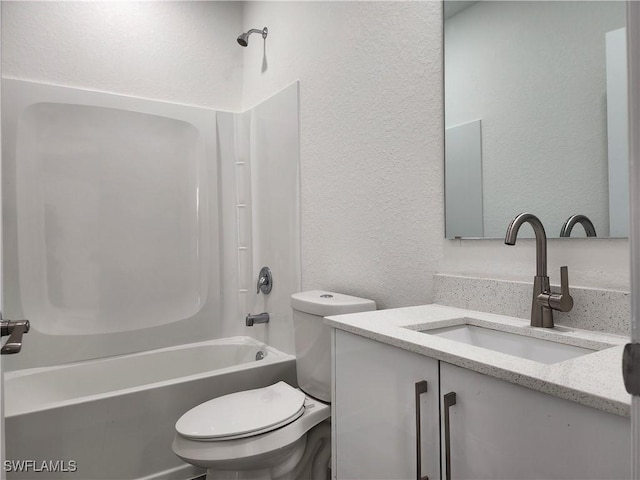 full bath featuring shower / bathing tub combination, toilet, vanity, and a textured wall