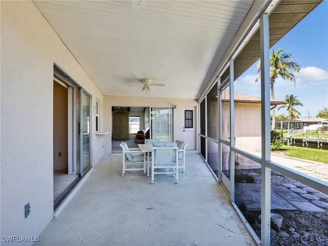 unfurnished sunroom featuring ceiling fan