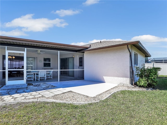 back of property with stucco siding, a ceiling fan, a patio, fence, and a sunroom