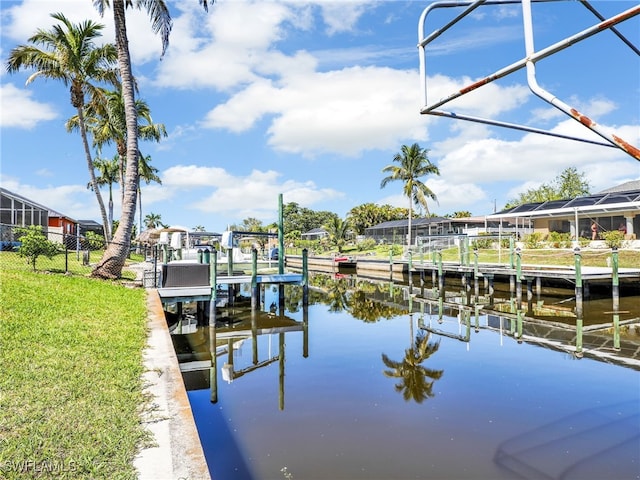 view of dock with a residential view, a water view, boat lift, and a lawn