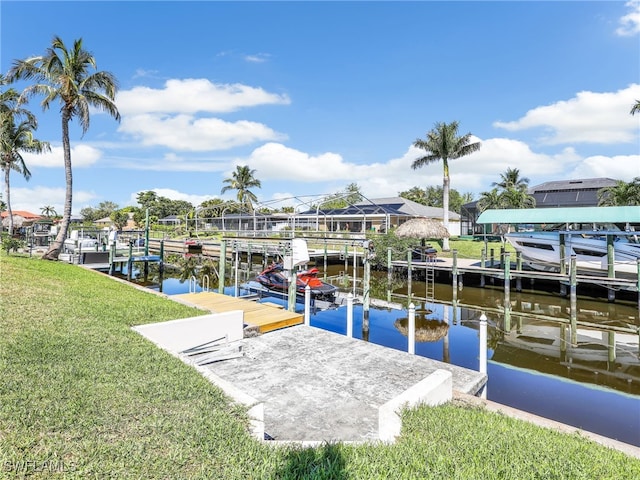 view of dock with a yard and a water view