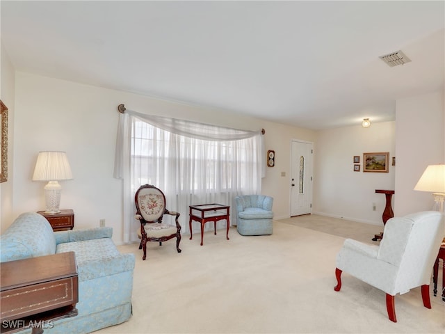 living area featuring visible vents, baseboards, and carpet floors