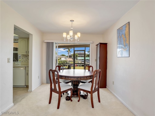 dining space with baseboards, light carpet, and an inviting chandelier