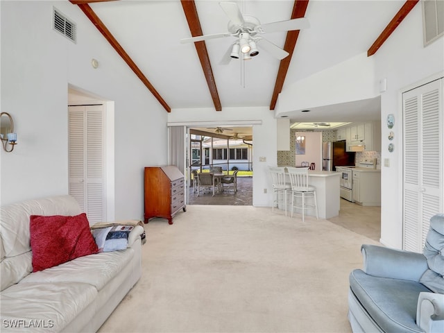 living area with visible vents, beam ceiling, light colored carpet, and a ceiling fan