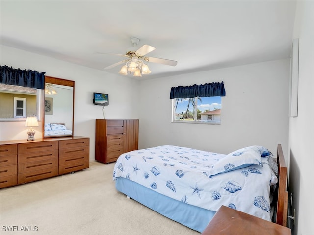 bedroom with light carpet and a ceiling fan