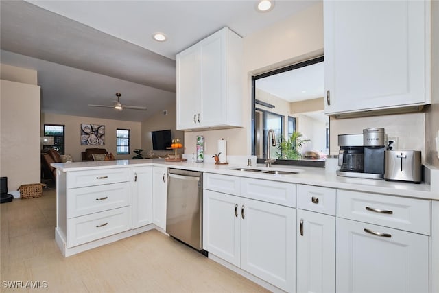 kitchen with a sink, white cabinetry, light countertops, and stainless steel dishwasher