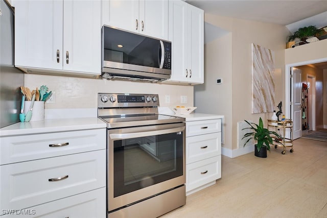 kitchen featuring light countertops, white cabinets, baseboards, and stainless steel appliances