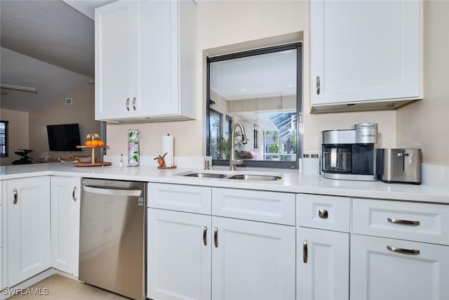 kitchen with stainless steel dishwasher, white cabinetry, and a sink