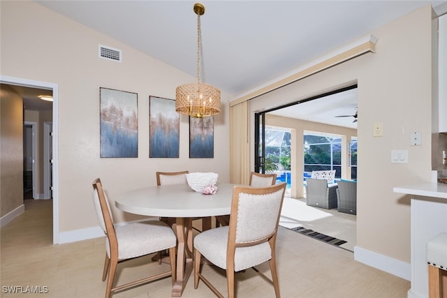 dining area with ceiling fan with notable chandelier, vaulted ceiling, baseboards, and visible vents