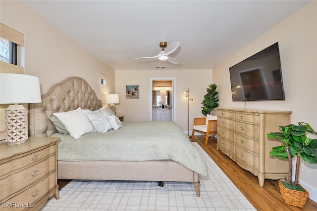 bedroom with ensuite bath, visible vents, light wood finished floors, and ceiling fan