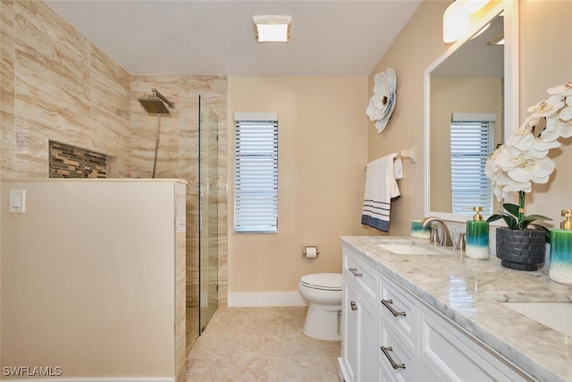 full bathroom with a sink, toilet, double vanity, and a walk in shower