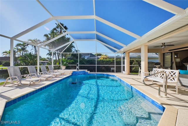 pool featuring a patio area, glass enclosure, and ceiling fan