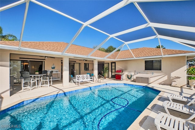 pool with a lanai, a patio area, and ceiling fan