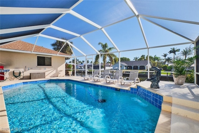 outdoor pool with glass enclosure and a patio