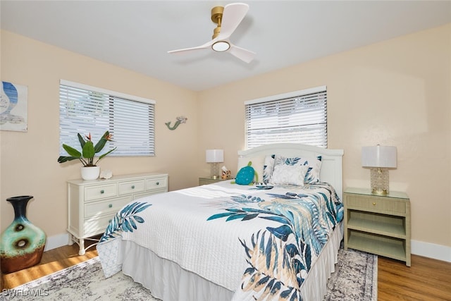 bedroom featuring baseboards, a ceiling fan, and light wood finished floors