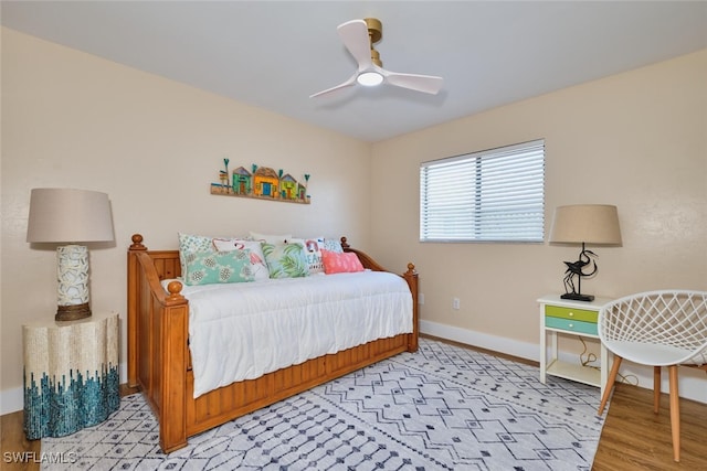 bedroom with light wood finished floors, ceiling fan, and baseboards