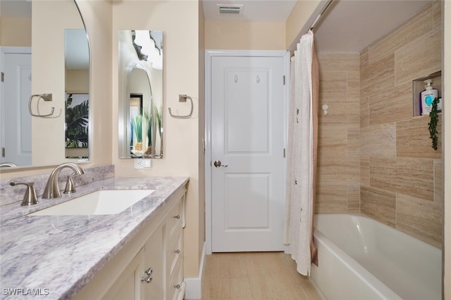 bathroom featuring visible vents, vanity, and shower / tub combo with curtain