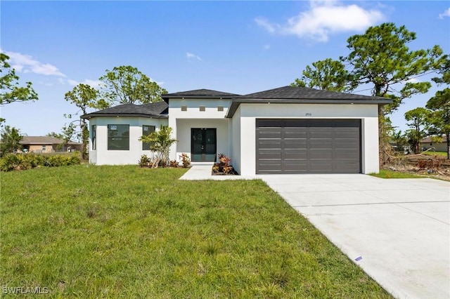 prairie-style home with stucco siding, driveway, a front yard, and a garage