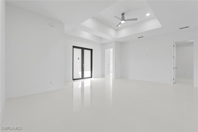 unfurnished room featuring visible vents, recessed lighting, french doors, a raised ceiling, and ceiling fan