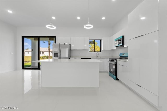 kitchen featuring a kitchen island, a sink, white cabinets, appliances with stainless steel finishes, and modern cabinets