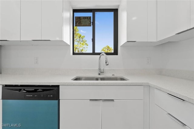 kitchen featuring dishwashing machine, white cabinetry, light countertops, and a sink