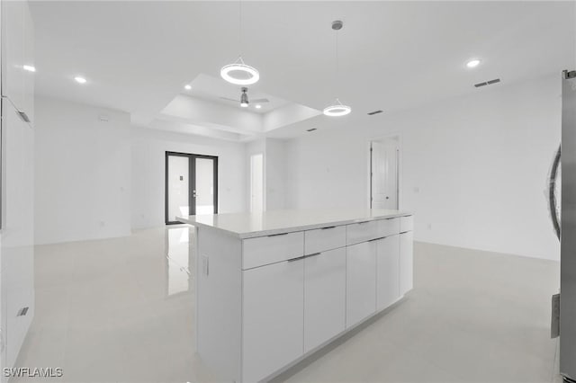 interior space with visible vents, open floor plan, recessed lighting, white cabinetry, and a raised ceiling