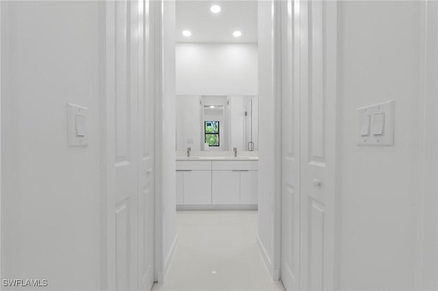 corridor with a sink and recessed lighting