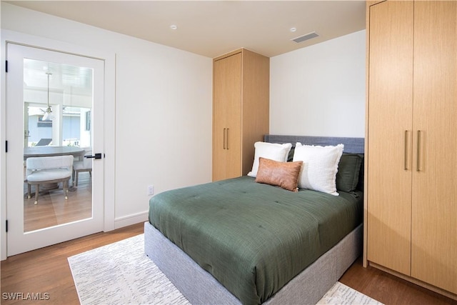 bedroom featuring visible vents and wood finished floors