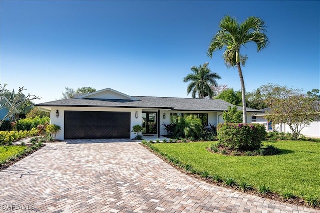 ranch-style house featuring stucco siding, an attached garage, decorative driveway, and a front yard