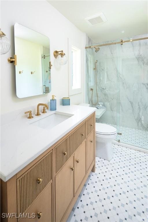 bathroom featuring a marble finish shower, visible vents, toilet, and vanity