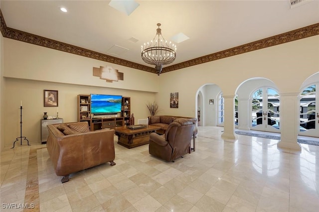 living area with ornate columns, an inviting chandelier, arched walkways, a towering ceiling, and crown molding