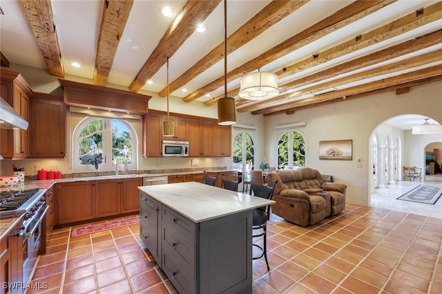 kitchen with stainless steel appliances, arched walkways, a breakfast bar, and open floor plan