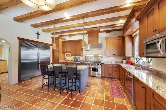 kitchen with a sink, a kitchen breakfast bar, light tile patterned flooring, extractor fan, and high end appliances