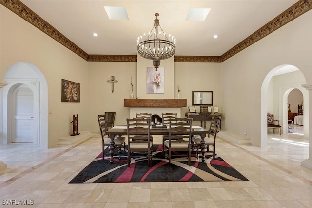 dining space featuring a notable chandelier, marble finish floor, recessed lighting, arched walkways, and baseboards