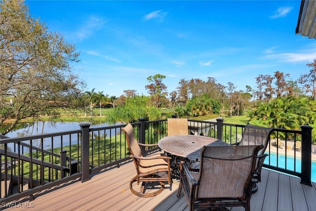 deck with outdoor dining area and a water view