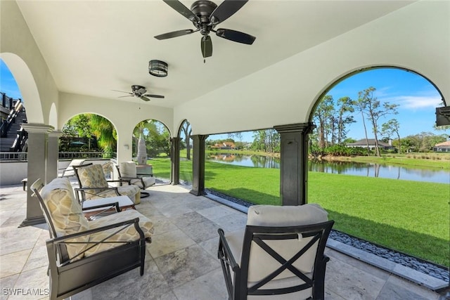 view of patio with ceiling fan and a water view