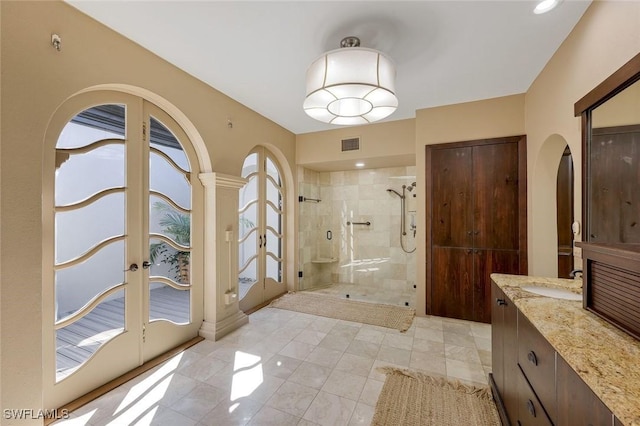 bathroom with visible vents, french doors, vanity, and a stall shower